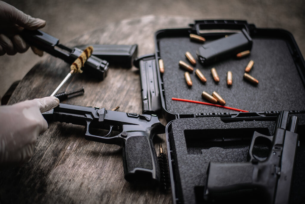 The gunsmith is sitting around cleaning the gun and disassembling and maintaining the pistol.