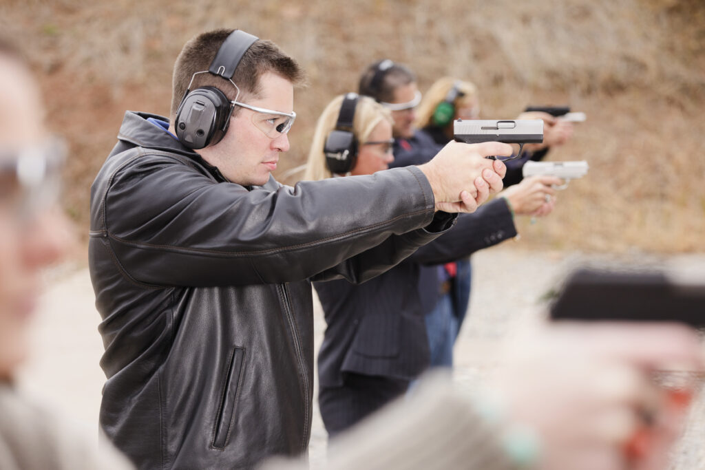 A group of people practicing at the gun range.