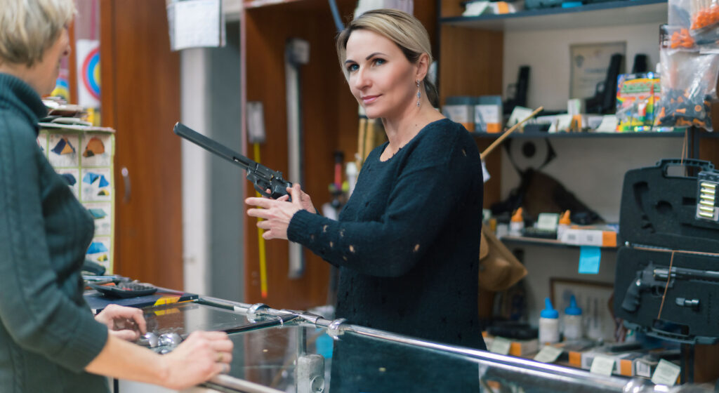 A woman buying the revolver in the small gun store